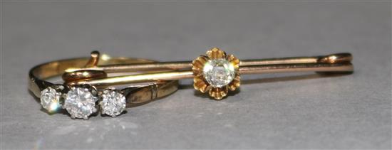 A gold and three stone diamond ring and a solitaire diamond set bar brooch.